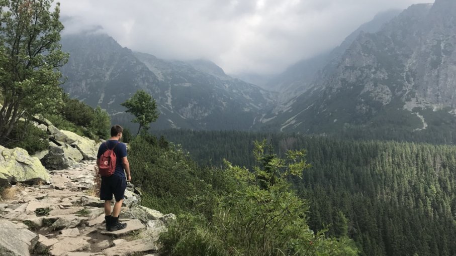 Muž kráča po chodníku v Tatrách počas zamračeného letného dňa