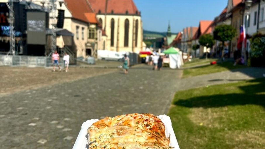 Podpecník na papierovej tácke na ulici s jarmočnými stánkami.