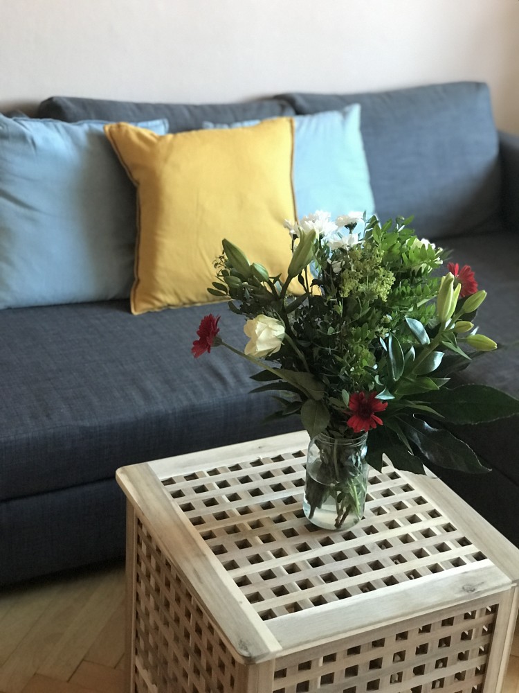 Váza letných kvetov na drevenom stolíku v obývačke