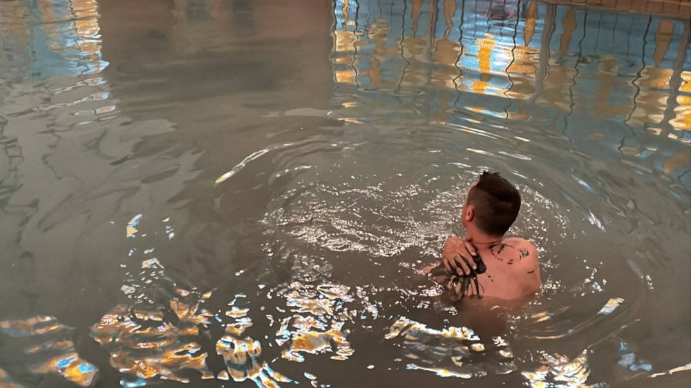Muž v bazené s piešťanským liečivým bahnom a liečivou sírnou vodou.