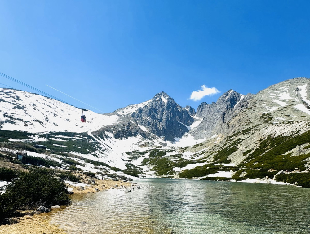 Lanovka v Tatrách ponad pleso počas zimného dňa.